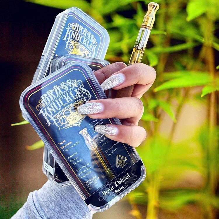 Girl Holding Brass Knuckles Vape Carts